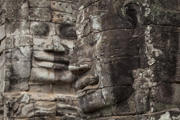 Fototapeta na wymiar Two stone carved faces in Bayon temple, Angkor Thom, Cambodia