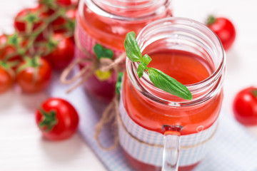 Fototapeta na wymiar Tomato Juice and Fresh Tomatoes on a White Wooden Background