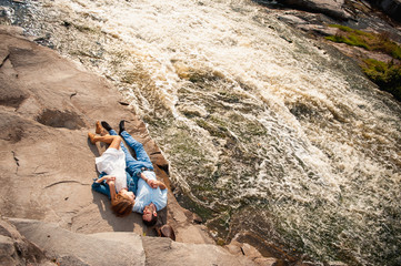  couple lying and hugging  near a mountain river