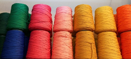  colored spools of thread and balls of wool for sale in the shop