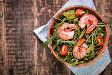Green salad with shrimps on wooden table.healthy food