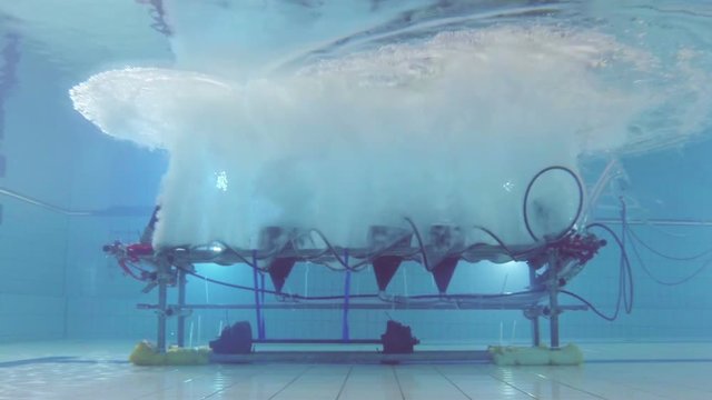 Low shot of bubble rig in swimming pool emitting bubbles