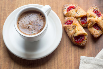 Cup of hot coffee and cookies on old wooden table