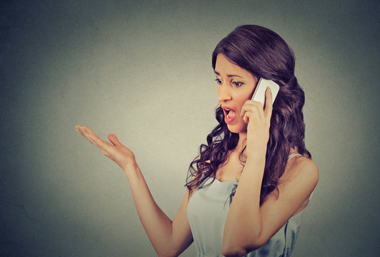 upset angry unhappy, serious woman talking on mobile phone screaming