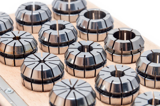 Metal collets for instruments for heavy industry in wooden box on white background