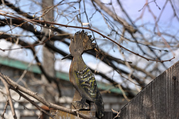 Bird hoopoe. Element of decor on a wooden fence