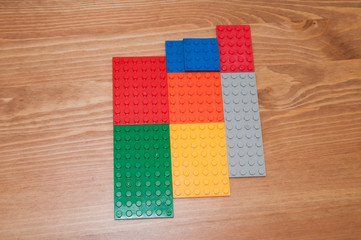 Colorful plastic toy blocks on a wooden table. 