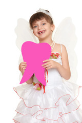 girl child lost tooth fairy dressed in white gown with wings show big tooth shape made from paper