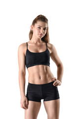 Fototapeta premium Front view of cutout young athletic woman holding her hands on waist and looking directly at the camera
