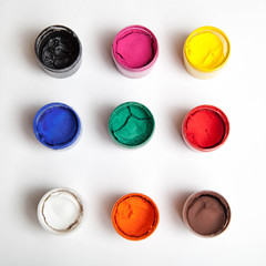 Gouache in jars in a row on a white background