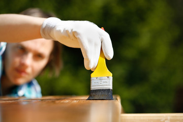 Woman carpenter inspecting freshly painted wood