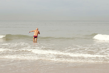 an elderly man comes in cold water