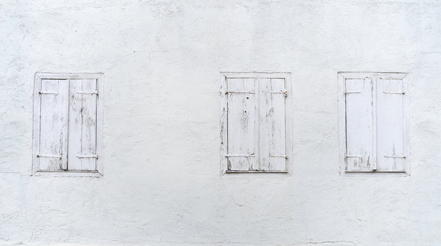 Drei alte Fenster mit geschlossenen Fensterläden 