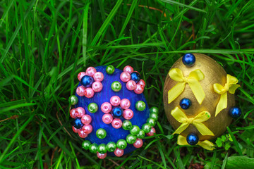 Two decorative Easter eggs in green grass