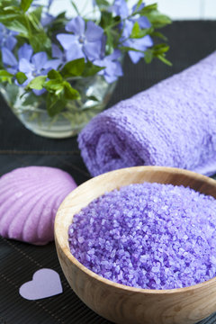Lavender bath salts with flowers, soap and towel