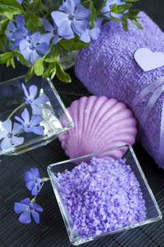 Lavender bath salts with flowers, soap and towel