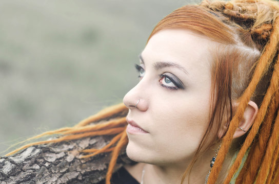 Redhead girl with dreadlocks and blue eyes looking up