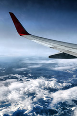Fototapeta na wymiar Wing of airplane above snowy mountains