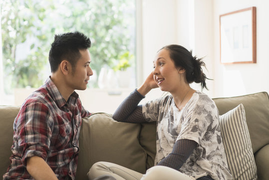 Couple talking on sofa in living room