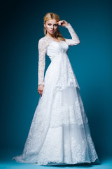Fototapeta na wymiar beautiful bride in wedding dress on blue