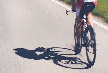Speedy shadow - rowerzysta na najwyższej prędkości w wyścigu triathlonowym. - 108073987