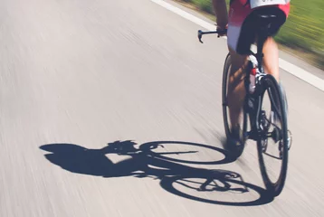 Tableaux ronds sur aluminium brossé Vélo Speedy shadow - Un cycliste à toute vitesse sur la course de triathlon.