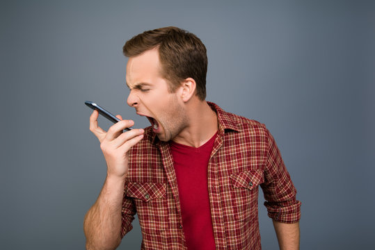 Portrait of angry young man screaming on his mobile phone