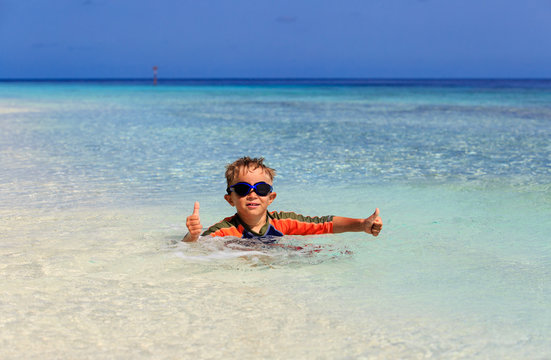 happy little boy swimming at tropical beach