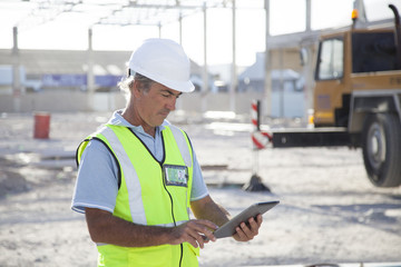 Caucasian construction worker using digital tablet at construction site