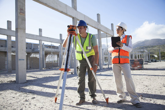 Surveyor and architect working at construction site