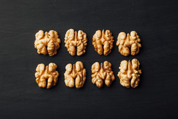 shelled walnuts in a row on black