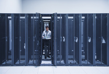 Hispanic technician working in server room