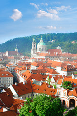 Naklejka premium Rofs of old Prague with church of St. Nicolas in spring
