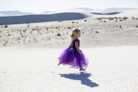 Caucasian girl walking on desert sand dunes