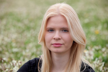 Naklejka premium Happy blonde girl surrounded by flowers