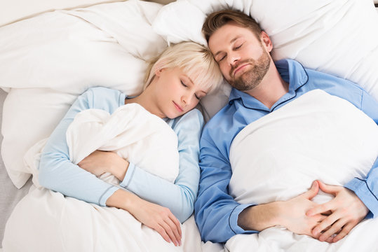 Young Couple Sleeping On Bed