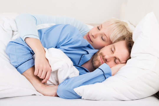 Young Couple Sleeping Together In Bed
