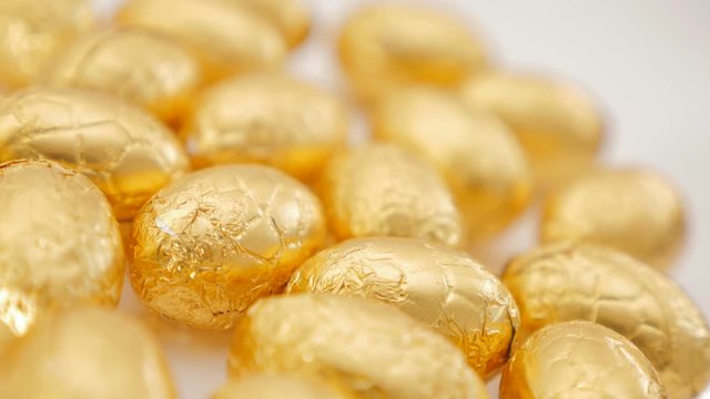 Easter chocolate eggs wrapped in golden foil grouped on whit surface 4K 2160p 30fps UltraHD footage - Golden chocolate egs wrapped in luxory gold foil 4K 3840X2160 UHD video