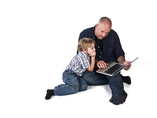 father using laptop while son watches him.