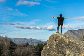 Young woman standing on the rock on the mountain