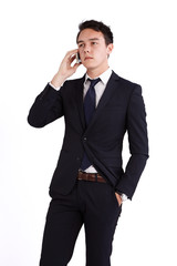 A young caucasian male businessman looking unhappy holding a mobile phone looking away from camera.