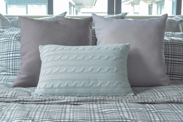 Light blue and gray pillows on cross pattern bedding