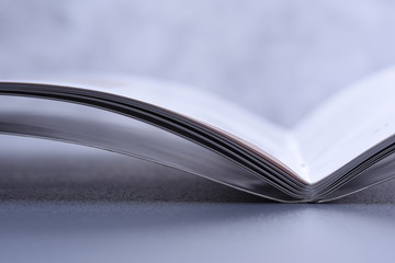 Closeup of open book on grey background, toned image