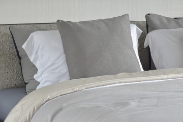 Gray pillow on white setting on bed with comfy blanket