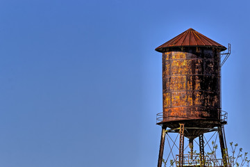 Old, rustic water tower with blue sky background