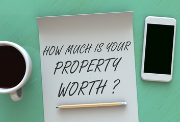 How Much Is Your Property Worth, message on paper, smart phone and coffee on table, 3D rendering