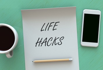 Life Hacks, message on paper, smart phone and coffee on table, 3D rendering