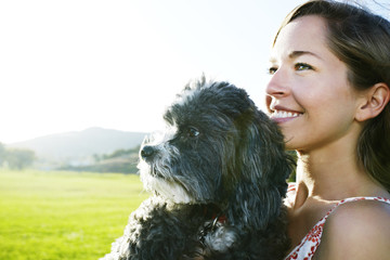 Caucasian woman holding dog outdoors