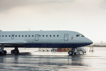 Obraz premium The aircraft on the airport apron under heavy rain