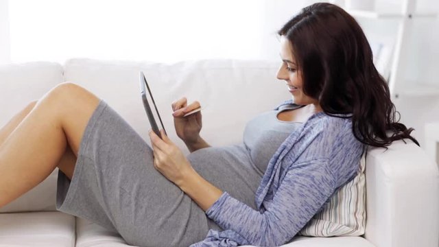pregnant woman with tablet pc and credit card